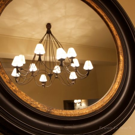 Chambre d'hôtel éclairée par un lustre, vue dans un miroir